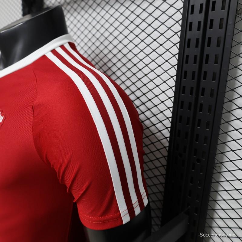 قميص لاعب مانشستر يونايتد باللون الأحمر مع ثلاث خطوط بيضاء على الكتفين - موسم 2026/2027