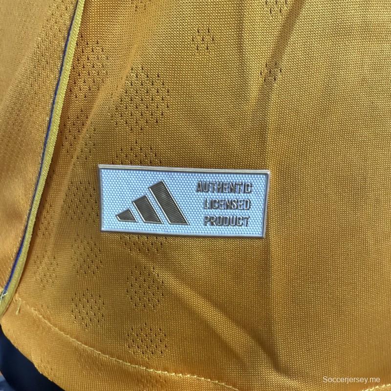 قميص اللاعب نسخة 25/26 لفريق تيغريس UANL باللون الذهبي مع شريط أزرق على الصدر، وشعار الذكرى الخامسة والستين، وقميص Sportiumbet