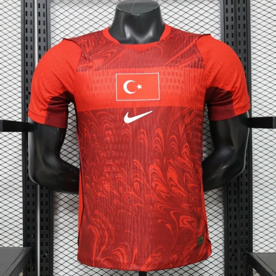 قميص اللاعب، إصدار 26/27، منتخب تركيا (مباريات على أرضه)، باللونين الأحمر والأحمر الداكن، بنقشة "إبرو" (الرخام)